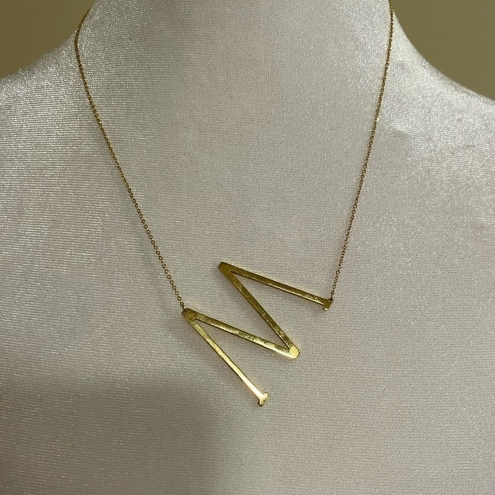 Gold toned sideways initial M necklace​​​​​​